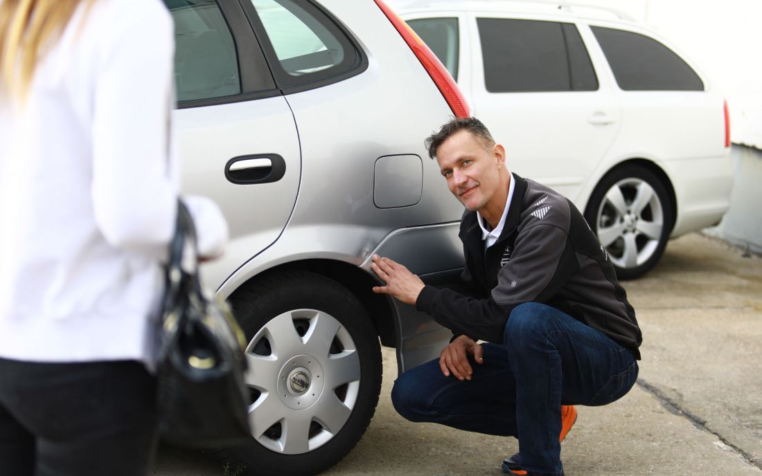Inhaber Heino Lindemann begutachtet Schäden am Gebrauchtwagen
